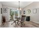 Dining area with modern lighting, a glass-top table, and access to the outdoor deck at 9747 W Peakview Dr, Littleton, CO 80123