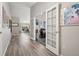 View of the spacious hallway that leads to the dining room, with vinyl floors and french doors at 9747 W Peakview Dr, Littleton, CO 80123