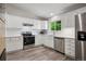 Modern kitchen with white cabinets, stainless steel appliances, vinyl flooring, and natural lighting at 9747 W Peakview Dr, Littleton, CO 80123