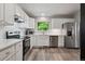 Updated kitchen featuring white cabinets, stainless steel appliances, and modern countertops at 9747 W Peakview Dr, Littleton, CO 80123