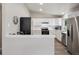 Open-concept kitchen with white cabinets, stainless steel appliances, and a breakfast bar at 9747 W Peakview Dr, Littleton, CO 80123