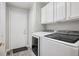 Efficient laundry area with washer, dryer, and storage cabinets for optimal convenience at 9747 W Peakview Dr, Littleton, CO 80123