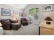 Cozy living room with large windows, leather furnishings, and ample natural light at 9747 W Peakview Dr, Littleton, CO 80123