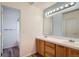 Bathroom with a double sink vanity, wood cabinets and a well-lit mirror at 6847 S Webster St # A, Littleton, CO 80128