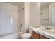 Bright bathroom featuring a white-tiled tub/shower, vanity, and a large mirror at 6847 S Webster St # A, Littleton, CO 80128