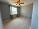Bedroom with neutral carpet, gray walls, ceiling fan, and window with patterned curtains at 9482 Kendrick Way, Arvada, CO 80007