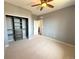 Bedroom with neutral carpet, gray walls, ceiling fan, open closet, and white door at 9482 Kendrick Way, Arvada, CO 80007