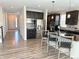 Open kitchen layout with dark cabinets, stainless steel appliances, and a view towards the entryway at 9482 Kendrick Way, Arvada, CO 80007