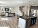 Open living space showing kitchen island, living room with fireplace, and staircase to the second floor at 9482 Kendrick Way, Arvada, CO 80007