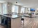 Open concept featuring a kitchen island that extends to the living room with a fireplace at 9482 Kendrick Way, Arvada, CO 80007