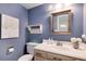 Charming powder room with blue walls, decorative mirror, and a classic sink at 6624 S Sycamore St, Littleton, CO 80120
