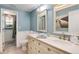 Charming bathroom with dual sinks, white cabinets, and bright blue walls, accented with wainscoting at 6624 S Sycamore St, Littleton, CO 80120