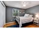 Bedroom with hardwood floors, a comfortable bed, and a large window overlooking the greenery at 6624 S Sycamore St, Littleton, CO 80120