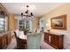 Elegant dining room featuring a chandelier, large window, and wooden furniture at 6624 S Sycamore St, Littleton, CO 80120