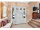 Bright entryway with a tiled floor, a white front door with sidelights, and a staircase leading to the upper level at 6624 S Sycamore St, Littleton, CO 80120