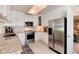 Bright kitchen with stainless steel appliances, white cabinets, and a view into the dining area at 6624 S Sycamore St, Littleton, CO 80120