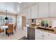 Open kitchen with granite countertops, white cabinets, and a view into the adjacent dining and living spaces at 6624 S Sycamore St, Littleton, CO 80120