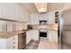 Well-lit kitchen with stainless steel appliances, granite countertops, and white cabinets for ample storage at 6624 S Sycamore St, Littleton, CO 80120
