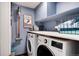 Efficient laundry room with modern washer and dryer, storage shelves, and a cleaning supplies at 6624 S Sycamore St, Littleton, CO 80120
