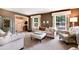 Cozy living room featuring two windows, a comfortable sofa, and an elegant ottoman at 6624 S Sycamore St, Littleton, CO 80120