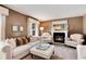 Inviting living room featuring a fireplace, comfortable sofas, and a decorative ottoman at 6624 S Sycamore St, Littleton, CO 80120