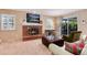 Cozy living room featuring a brick fireplace, a plush ottoman, and sliding doors to the backyard at 6624 S Sycamore St, Littleton, CO 80120