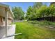 Relax on the covered patio overlooking a large, beautifully maintained backyard with a stone retaining wall at 1843 S Pierson Ct, Lakewood, CO 80232