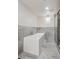 Modern bathroom with a white soaking tub surrounded by gray marbled tile and a glass shower door at 1843 S Pierson Ct, Lakewood, CO 80232