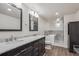 Modern bathroom with a double vanity, black cabinets, marble countertops, and a soaking tub at 1843 S Pierson Ct, Lakewood, CO 80232