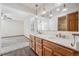 Bright bathroom with double sinks, marble countertops, and a mirrored wall over wood cabinets at 1843 S Pierson Ct, Lakewood, CO 80232