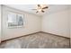 Bright, empty bedroom with a window, ceiling fan, neutral walls, and plush carpeting at 1843 S Pierson Ct, Lakewood, CO 80232