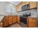 Bright kitchen features stainless appliances, granite counters, a sink beneath a window, and wood-look flooring at 1843 S Pierson Ct, Lakewood, CO 80232