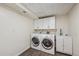 Clean laundry room with modern appliances, white cabinetry, sink, and luxury vinyl plank flooring at 1843 S Pierson Ct, Lakewood, CO 80232