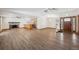 Open-concept living room featuring hardwood floors, a fireplace, and a view of the kitchen and front door at 1843 S Pierson Ct, Lakewood, CO 80232