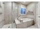 Bathroom featuring a shower and tub combination, white tile, and a window with plantation shutters at 3242 Waterfront Dr, Monument, CO 80132