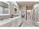 Spacious bathroom with double vanities, granite countertops, tiled floors, and walk-in shower at 3242 Waterfront Dr, Monument, CO 80132