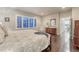 Bedroom with hardwood floors, plantation shutters, neutral tones, and a glimpse into the kitchen at 3242 Waterfront Dr, Monument, CO 80132