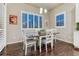 Dining room featuring a modern table, hardwood floors, and natural light from the shuttered windows at 3242 Waterfront Dr, Monument, CO 80132