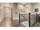 Hallway with hardwood floors, neutral paint, archways, and wrought iron stair railing at 3242 Waterfront Dr, Monument, CO 80132