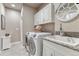 Laundry room with white cabinets, granite countertops, utility sink, and modern appliances at 3242 Waterfront Dr, Monument, CO 80132