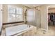 Bright bathroom featuring a tub, separate shower, and large window with blinds at 14110 Greenfield Loop, Parker, CO 80134
