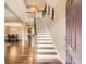 Bright foyer with hardwood floors, staircase, and view of dining area with large clock in this beautiful home at 14110 Greenfield Loop, Parker, CO 80134