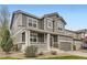 Charming gray two-story home featuring a welcoming front porch and well-manicured lawn and a two car garage at 14110 Greenfield Loop, Parker, CO 80134