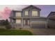 Charming gray two-story home featuring a welcoming front porch and well-manicured lawn and a two car garage at 14110 Greenfield Loop, Parker, CO 80134