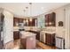 A stylish kitchen features stainless appliances, mosaic backsplash, granite countertops and dark wood cabinets at 14110 Greenfield Loop, Parker, CO 80134