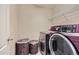 Modern laundry room with front-load washer and dryer and storage baskets at 14110 Greenfield Loop, Parker, CO 80134