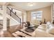 Open concept features hardwood floors, neutral paint and ample natural light with view of staircase and front entrance at 14110 Greenfield Loop, Parker, CO 80134