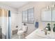 Bright bathroom featuring a shower-tub combo, window, and vanity with sink at 1838 Wilson Cir, Erie, CO 80516