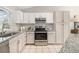 Well-lit kitchen boasting granite counters, stainless steel appliances, and sleek white cabinets at 1838 Wilson Cir, Erie, CO 80516