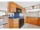 Efficient kitchen layout showcases tile counters, wooden cabinets and a sleek black oven range at 2130 Frontier Ln, Franktown, CO 80116